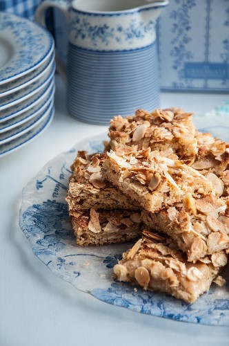 Pieces of almond and apple tray bake on a serving plate