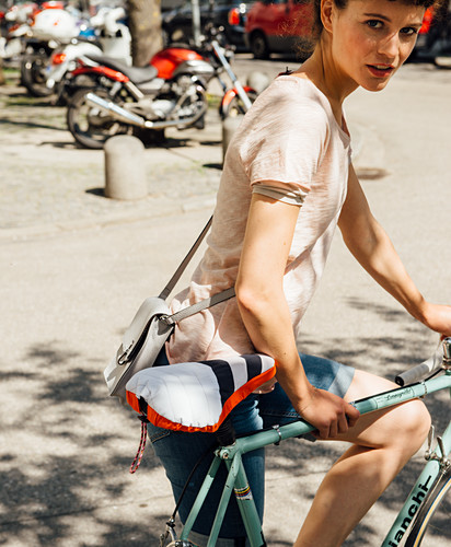 A woman on a bike with a homemade saddle cover