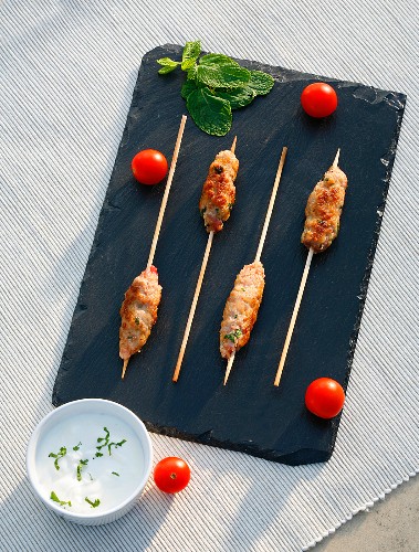 Minced meat skewers with yoghurt sauce and tomatoes