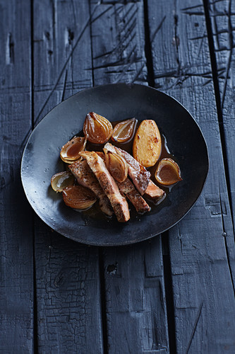 Roasted pork collar in a cumin broth with onions