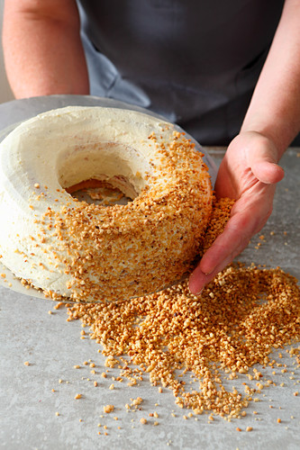 A Frankfurt wreath cake being made: brittle being pushed on by hand