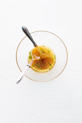 Vinaigrette in a glass bowl with salad servers