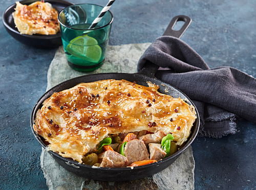 Baked pork with vegetables with puff pastry cap