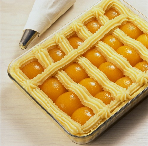 Piping marzipan lattice on apricot cake