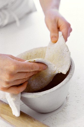 Dessertförmchen mit Teig für englischen Pudding auskleiden