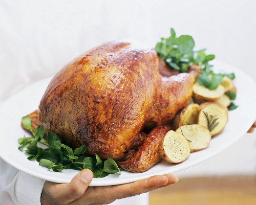 Roast turkey, served with herbs and baked potatoes