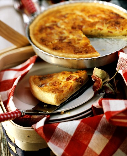 Quiche Lorraine in baking dish and one piece on plate