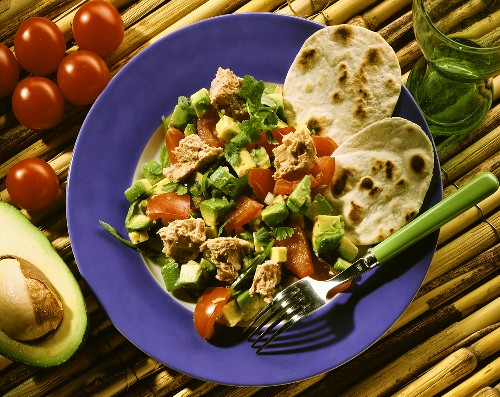 Tacos with tuna salad, avocados & tomatoes on plate