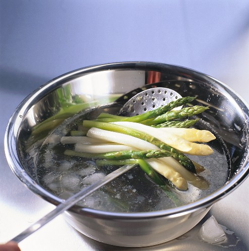Refreshing cooked asparagus in iced water