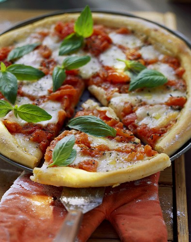Pizza Margherita mit Basilikum (angeschnitten)