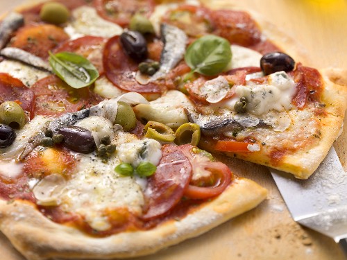 Tomatenpizza mit Salami, Gorgonzola, Sardellen und Oliven