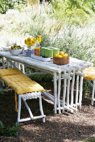 Outdoor picnic with crockery on DIY table made from wooden poles