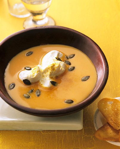 Pumpkin soup with whipped cream and pumpkin seeds