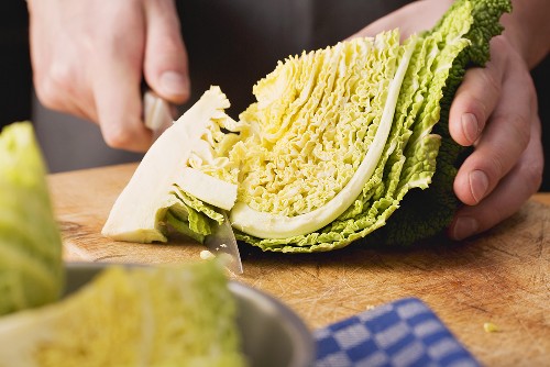 Savoy cabbage being prepared: stalk being removed