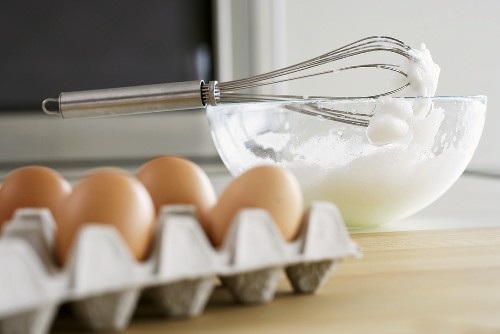 Steif geschlagener Eisschnee in Rührschüssel, Eierkarton