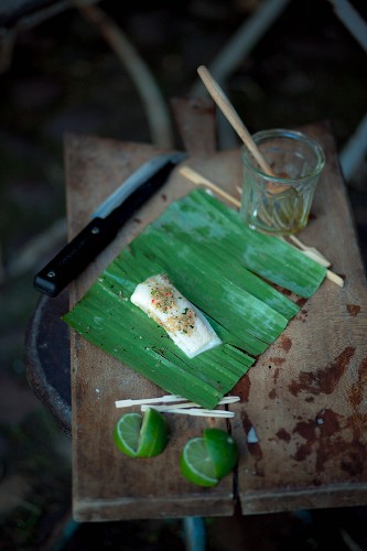 Grilling marinated halibut wrapped in banana leaves