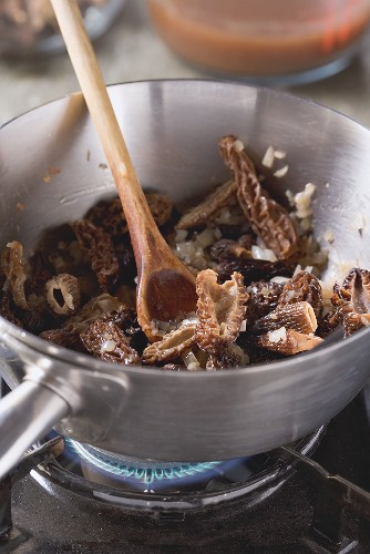 Morels being fried with diced shallots