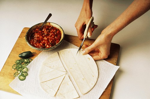 Tortilla in Dreiecke schneiden; Salsa und Chilischoten
