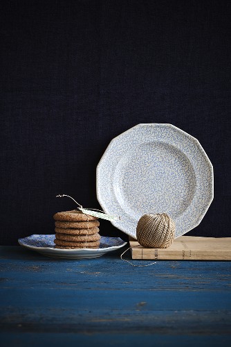A stack of sugar biscuits and a ribbon, kitchen twine and a plate