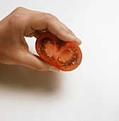 Removing the seeds from a halved tomato