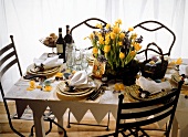 A festively laid Easter table in a country house style decorated with spring flowers