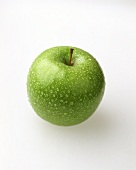 A Granny Smith apple with drops of water