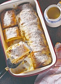 Curd cheese strudel with icing sugar in baking dish
