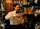 Waiter Pouring Grappa into a Glass