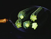 Fresh whole courgettes in the pan