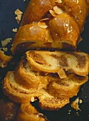 Plaited nut loaf with flaked almonds, slices cut