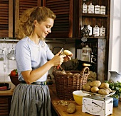 A Woman Peeling Potatoes in a Kitchen