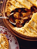 Steak and kidney pie in pie dish with pastry lid