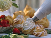 Filling cream puffs with whipped cream using a piping bag