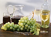 Still life with white grapes, wine glasses & bottles