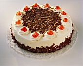 A Black Forest cherry gateau against white background