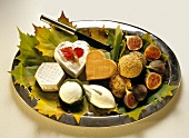 Cheese platter with pears, figs, sesame balls & leaves