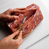 Preparing smoked pork rib (Kasseler, cutting into meat)