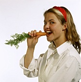 A woman Biting into a Carrot