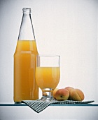 Peach Juice in a Bottle and in a Glass; Peaches
