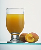 A Glass of Peach Juice with Fresh Peaches