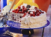 Ice cream gateau with meringue and berries, a piece cut