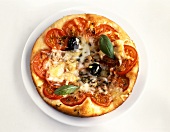 Eine Pizza mit Tomaten, Oliven & Basilikum