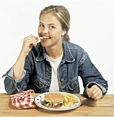 Woman Eating Hamburger and French Fries