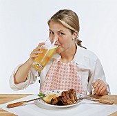 Woman Drinking Beer with her Dinner