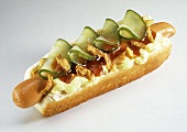 A Hot Dog on a Bun with Pickles; Condiments