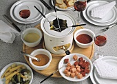 Fondue with meat, mixed pickles and various sauces