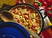 Carp goulash with red peppers in blue pot