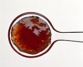 Strawberry jam on Plexiglas spoon