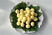 Butter balls on vine leaves in white bowl
