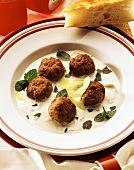 Meatballs with tzaziki sauce and mint leaves